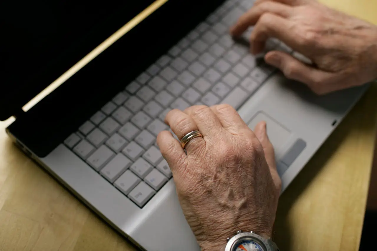 Hände einer Seniorin bedienen Computertastatur